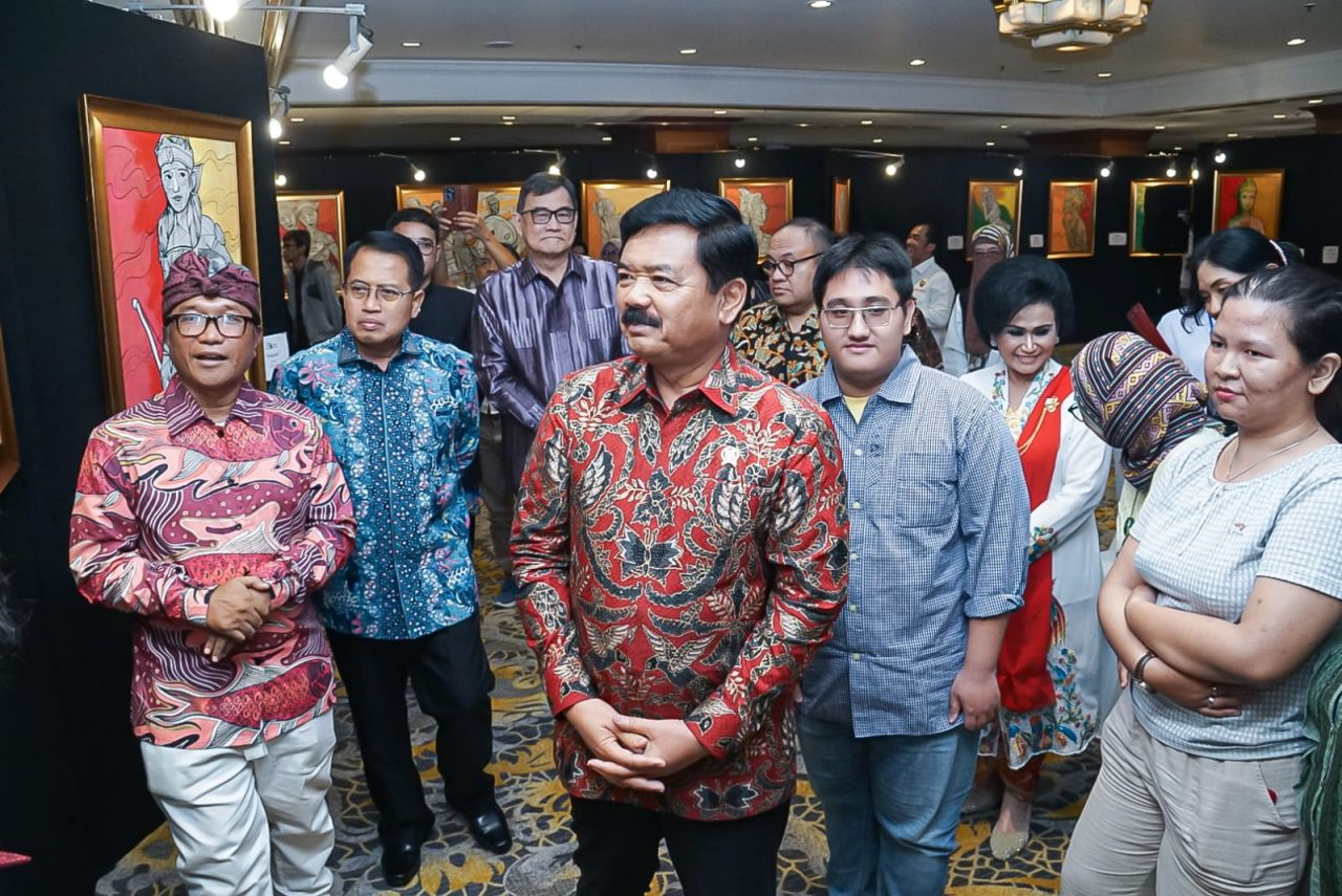 Pelukis nasional, Andri Wintarso alias Tarso saat mendampingi Menko Polhukam Hadi Tjahjanto dalam pameran Lukisan karya Tarso.